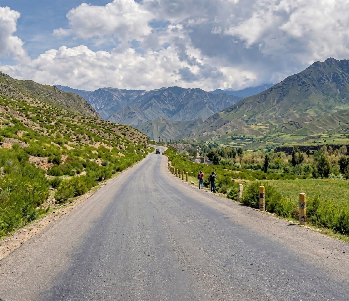 A newly paved road on the Paroon route running through green mountain terrain in Nuristan province